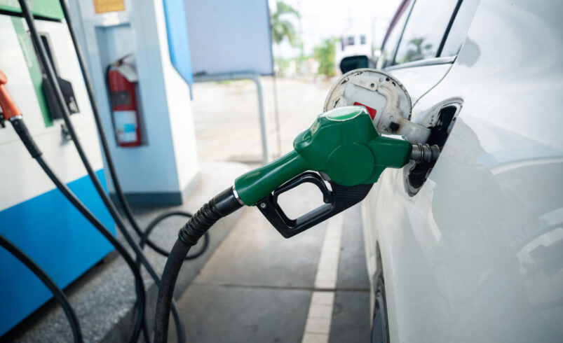 transport and industry concept. refilling the car. a refueling valve is inserted into the fuel filler neck. white car at gas station being filled with fuel